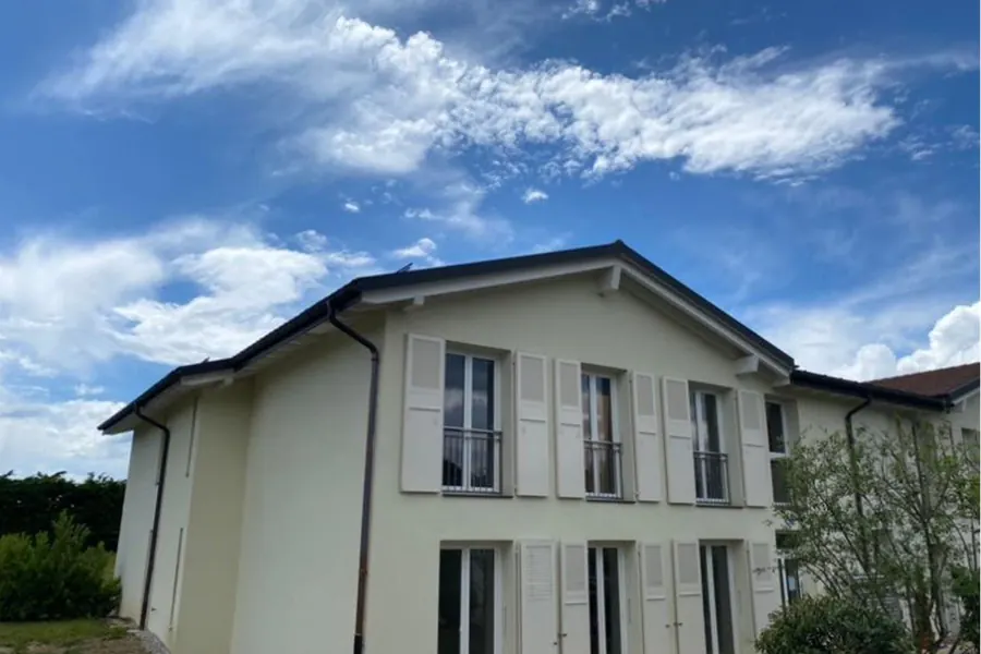 Façade de villa crème repeinte, volets et avant-toit remis à neuf